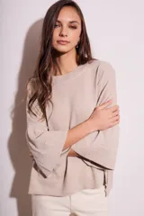 Sweater color salmón de tejido de punto con lurex, corte oversize, cuello redondo y mangas 3/4 acampanadas.