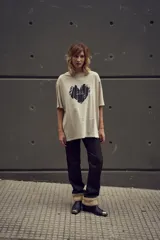 Remera color crema de corte holgado con estampado de corazón negro en el frente.
