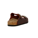 Sandalias bajas de cuero color marrón con dos tiras anchas ajustables con hebilla metálica.