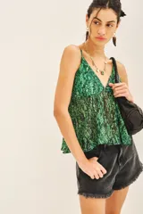 Top bretelero con estampado reptil en tonos verdes, confeccionado en gasa con lurex y forrería a tono en tazas. Posee elástico en la parte de la espalda.