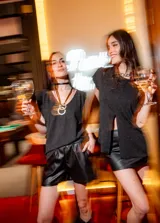 Blusa negra de lurex con tajo en la parte delantera y corte suelto.
