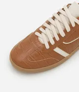 Championes chuteira color marrón con textura crocco, cordones blancos, suela color caramelo y detalles en blanco en los laterales y el talón.