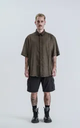 Camisa manga corta color verde militar, de corte amplio y confeccionada en lino.