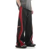 Pantalón deportivo negro de corte ancho, con cintura elástica ajustable con cordón, bolsillos laterales con cierre y detalles en rojo y blanco en los laterales.