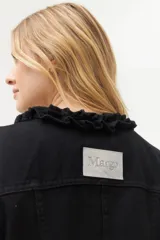 Campera de jean negra con cuello mao y volados, cierre frontal con botones metálicos y bolsillos de parche en el pecho.