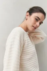 Sweater negro tramado de silueta relajada, con combinación de texturas en el tejido y mangas abullonadas con puños elastizados.