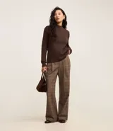 Sweater negro de punto con cuello redondo, puños y ruedo acanalados. Incluye cuello, puños y ruedo de camisa celeste a rayas.