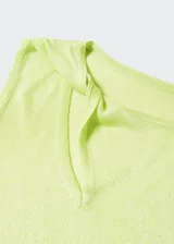 Buzo de punto fino color verde lima, con escote asimétrico y una manga larga. Tiene una abertura en el cuello y terminaciones acanaladas.