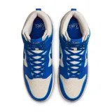 Zapatillas Nike Dunk Hi Retro SE de caña alta, color blanco y azul, con suela de goma color caramelo.