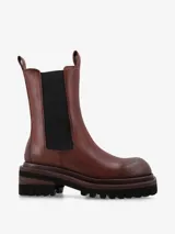 Bota de cuero estilo Chelsea con caña media y paneles elásticos laterales en color negro. Posee tiradores en la parte superior para facilitar el calce y una suela track de goma robusta con plataforma.