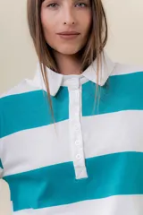 Sweater de manga larga con diseño de rayas anchas horizontales en azul marino y blanco. Posee cuello polo con cartera de botones y calce relajado.