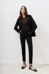Pantalón jean negro de corte slim con detalles de tachas plateadas en los bolsillos delanteros y en el ruedo.