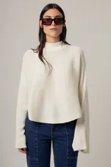 Sweater rojo de punto con cuello alto y mangas largas acampanadas.