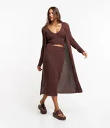 Conjunto de falda midi y cárdigan largo de punto calado color marrón. Incluye un top corto tejido al tono.
