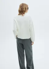 Sweater blanco de punto fino con cuello polo y escote en V.