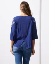 Blusa azul con escote redondo, mangas 3/4 con bordado floral y abertura central con botones. Marca Forgotten Grace.
