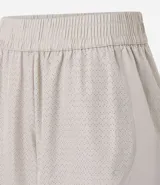 Bermuda deportiva corta de microfibra ligera, color lila, con cintura elástica funcional y textura de agueros.