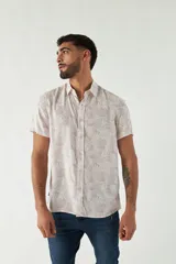 Camisa de hombre estampada, de manga corta y fit slim. Presenta cartera abotonada y logo bordado.