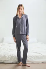 Pijama de viscosa y poliamida color gris con ribetes blancos, compuesto por camisa de manga larga con botones y pantalón largo.