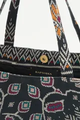 Bolso tipo tote bag negro con estampado geométrico multicolor y la palabra 'Liberté' bordada en dorado.