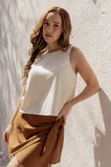 Blusa sin mangas color crema, de corte holgado y confeccionada en lino y algodón.