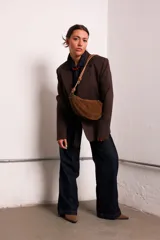 Cartera tipo sobre color bordó, confeccionada en PU tipo gamuza, con correa regulable de nudos chunky y cierre superior.