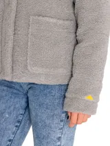 Chaqueta polar de mujer color negro, con cuello alto y cierre frontal con broches ocultos. Tiene bolsillos laterales y un bolsillo interior en el pecho. Presenta logo de Caterpillar en el bolsillo.