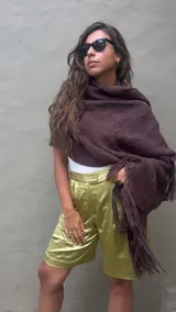 Ruana artesanal tejida en telar con lana merino de alta calidad, color marrón chocolate obtenido con teñido natural. Presenta un tejido grueso y textura visible, con flecos largos en el borde inferior.