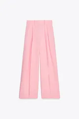 Pantalón rosa de tiro medio con trabillas en la cintura, bolsillos laterales, pinzas delanteras y pierna ancha. Cierre frontal con cremallera, botón y ganchos metálicos.