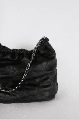 Cartera tipo bolso capitoneada de cuero color rojo, con asa de cadena plateada entrelazada con cuero. Forrada por dentro y con bolsillo interno.