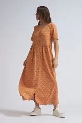 Vestido midi color ocre con estampado de abanicos en color crudo, corte evasé, escote en V, mangas cortas y abotonadura frontal.