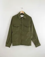 Camisa de pana color beige, de manga larga, con cuello camisero, cierre frontal de botones y dos bolsillos de parche con solapa en el pecho. Presenta un corte recto y holgado.