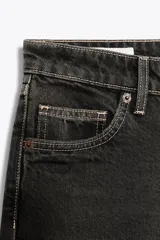 Pantalón de jean celeste claro, de tiro bajo, corte wide leg y largo hasta el tobillo. Tiene cinco bolsillos, cierre frontal con cremallera y botón metálico.