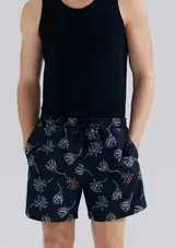 Short de baño blanco con estampado de hojas negras.