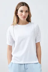 Remera roja de algodón con cuello redondo y mangas cortas con detalle de broderie. Corte clásico.