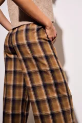 Pantalón de tiro medio, corte recto y pierna ancha, con estampado de cuadros escoceses en tonos marrón, beige y negro.