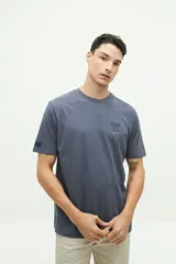 Remera blanca de manga corta con cuello redondo y estampado pequeño en el pecho con una columna griega y texto en color celeste.