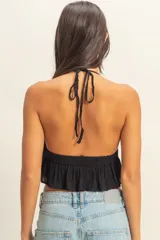 Top blanco con textura y peplum, escote halter y tirantes finos.