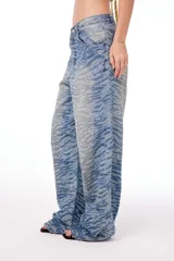 Pantalón de jean oversized de tiro bajo, color azul lavado, con estampado de tigresa grabado con láser.