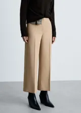 Pantalón de vestir color beige, de corte palazzo y tiro medio.