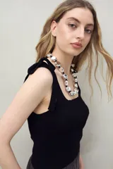 Top tejido color beige con tiras para anudar en los hombros y diseño tramado acanalado.