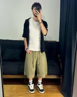 Bermuda de corte baggy color verde con efecto gastado. Presenta costura vertical trasera en cada pierna y detalle artesanal visible en el bajo. Incluye un cordón extra confeccionado en la misma tela.