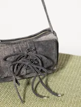 Mini cartera tipo baguette color rosa, realizada en cuero ovino. Tiene acceso mediante un cierre metálico, interior forrado en tejido jacquard con bolsillo y bolsillos frontales con apliques metálicos níquel.