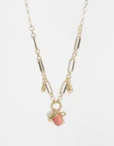Collar corto dorado con cadena de eslabones combinados y dijes colgantes de frutilla rosa brillante, hongo dorado, moño dorado y perla.