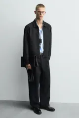 Bolso tipo shopper fabricado en cuero negro. Tiene un bolsillo interior plano con cierre mediante cremallera y asas de cuero.