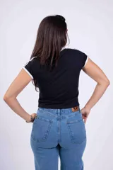 Chomba blanca con cuello polo y mangas cortas con ribete negro. Estampado frontal con la inscripción "Los Angeles" en letras negras.