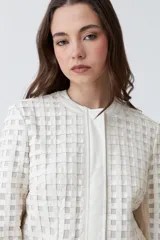 Chaqueta color crudo de eco cuero con detalle de tul calado.