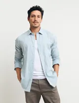 Camisa celeste de manga larga con cuello button-down, confeccionada en tejido rústico de algodón y lino.