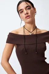 Top tejido color blanco con escote bardot que deja los hombros al descubierto y punto acanalado.