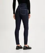 Pantalón de jean skinny de tiro medio color azul oscuro, con bolsillos delanteros y traseros, trabillas anchas y botón metálico.